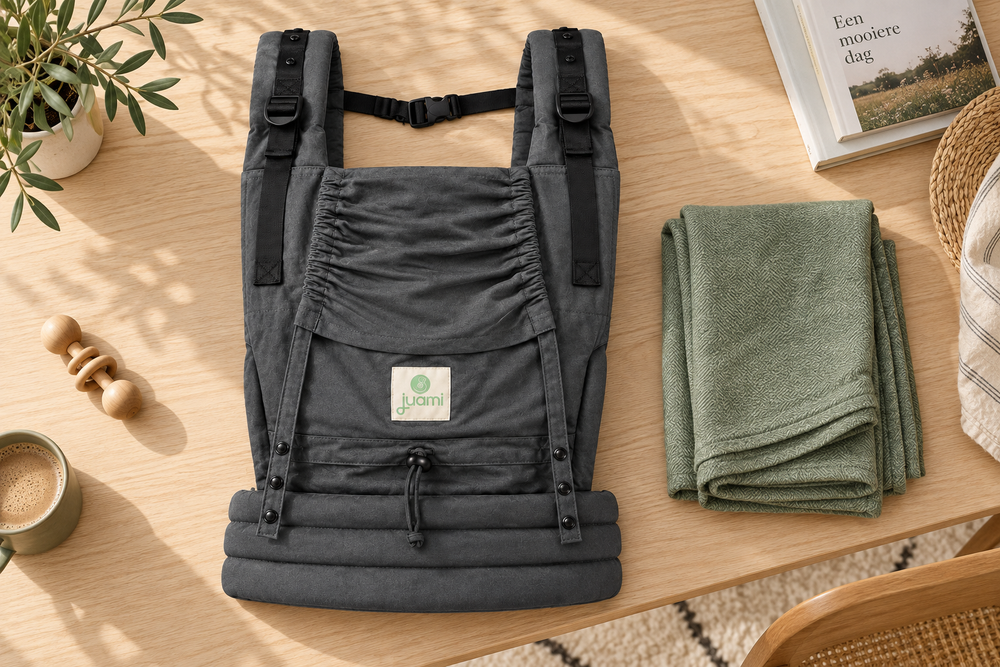 Antracietgrijze draagzak met verstelbare banden naast een gevouwen groene draagdoek.
