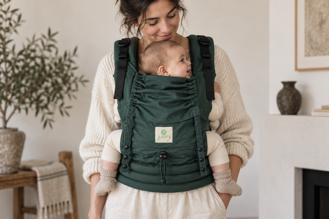 Baby in een groene draagzak met gebogen knieën hoger dan de billen en ondersteunde bovenbenen.