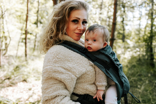 Moeder en baby genieten samen van een wandeling in de natuur met de ergonomische draagzak van Juami.